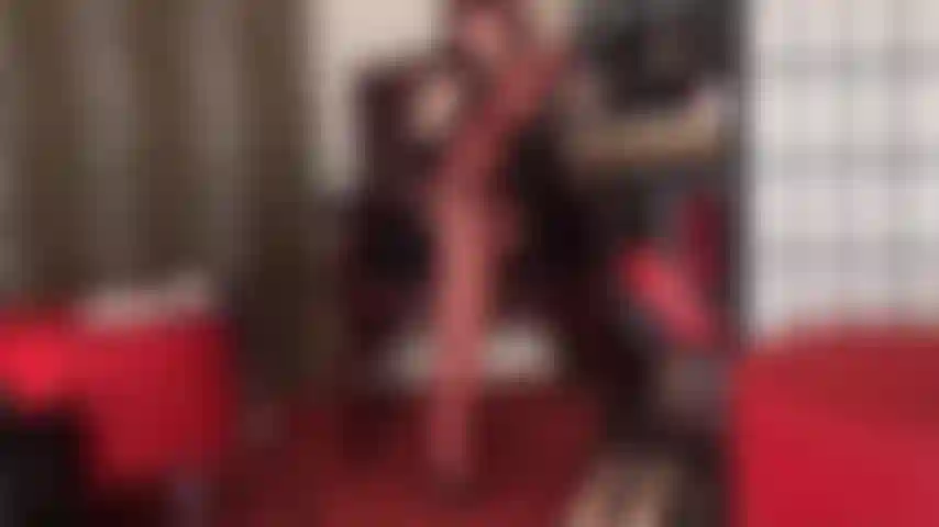 Seduzione con collant in strati di nylon rosso lucido e sabot in pelle con tacco alto.