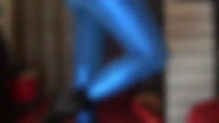 Gambe lunghe e culo sexy in leggings blu metallizzati lucidi.