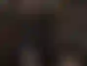 Indosso una tuta nera in lattice, uno strapon bianco e una maschera in collant.