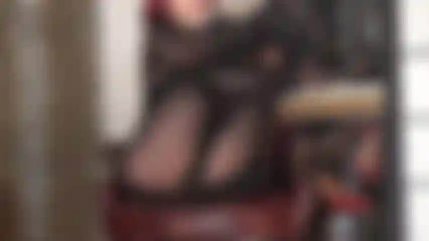 Collant neri super lucidi e cappuccio in lycra spandex. La padrona ha i suoi bellissimi piedi in nylon alzati.