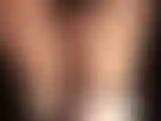 Con pantaloncini sexy in raso nero, collant lucidi e stivali in raso.