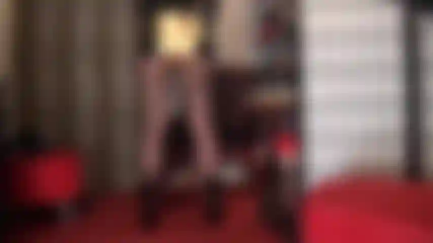 La padrona mostra il suo sedere in pantaloncini sexy color oro metallizzato lucido, le sue gambe possenti in collant neri trasparenti, abbinati a stivaletti corti neri verniciati.