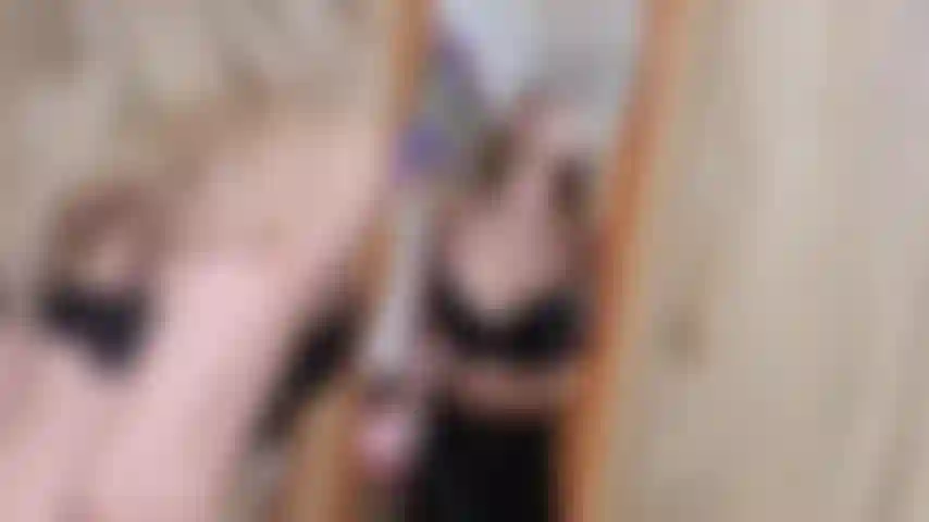 Una bionda viziosa che sputa sullo specchio e gioca con la saliva mentre indossa la pelle.