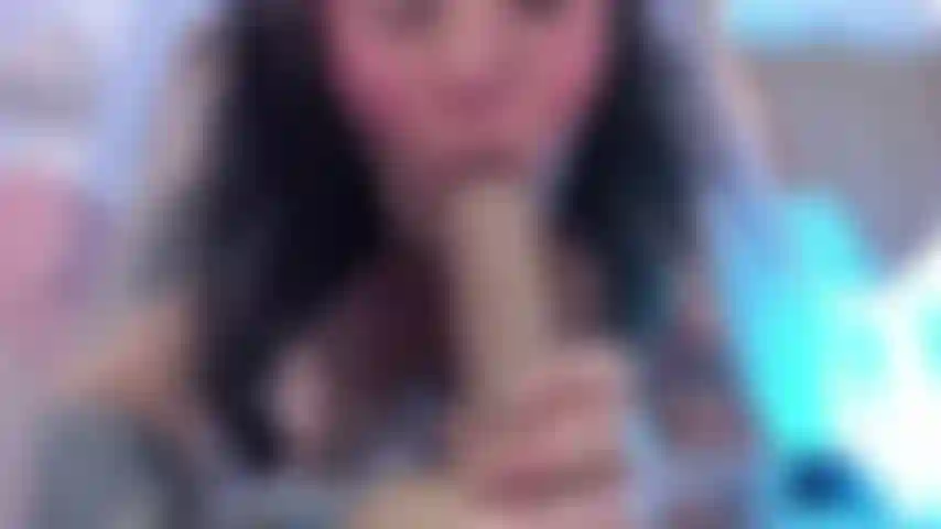 A black haired woman sucking a dildo