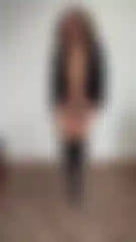 In cappotto nero, infradito e stivali, che fa la modella per voi.