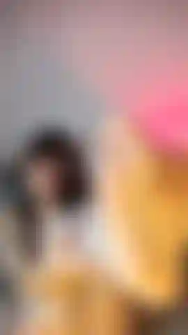 Una gnocca in lingerie bianca e calze a rete, che si accarezza i piedi e sorride giocosamente alla telecamera.