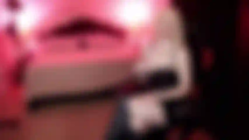 Una dominatrice che indossa pelle e stivali e ti rinchiude nella castità.