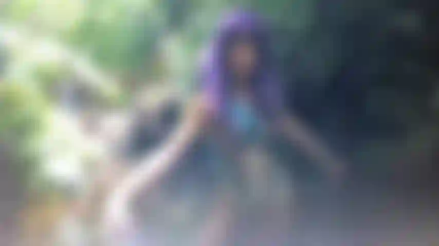 Ballo con parrucca viola e body nudo.