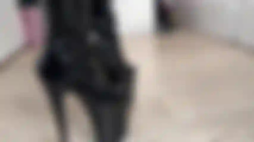 Una ragazza mascherata in lattice con stivali.