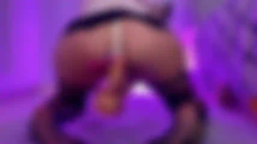 Calze e un top a rete e indossa un dildo da equitazione.